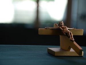 Ein kleines Kreuz mit Jesus auf einem Tisch